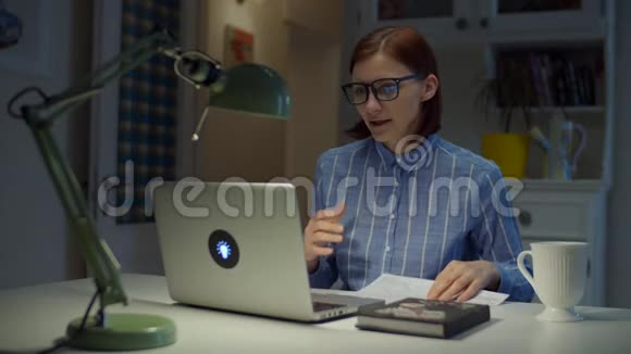 30多岁的年轻女教师戴着眼镜说话带着图表看着家里的笔记本电脑网上在线视频的预览图