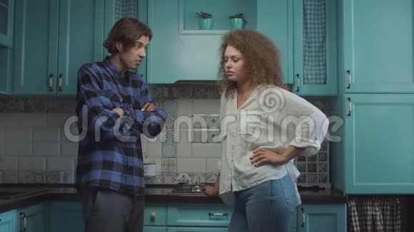 年轻的20多岁的夫妇站在家里的蓝色厨房争吵男朋友尖叫指责女朋友家庭嫉妒视频的预览图