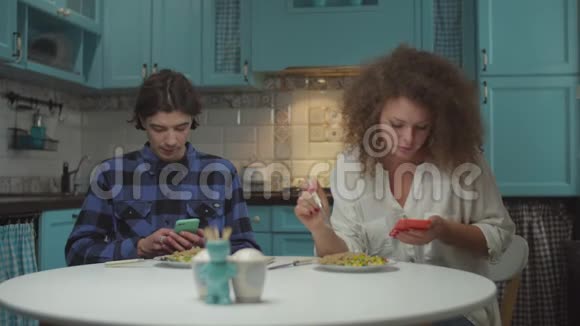 20多岁的年轻人在蓝色厨房里用小玩意吃饭时互相嘴男人和女人一起吃饭视频的预览图