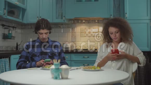 20多岁的年轻人在蓝色厨房里用小玩意吃饭时互相嘴男人和女人一起吃饭视频的预览图
