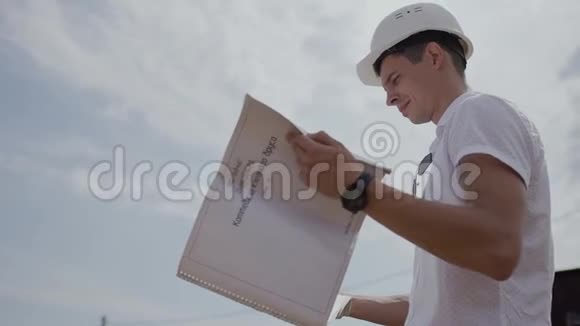 建筑工人看建筑工地的纸房工程视频的预览图