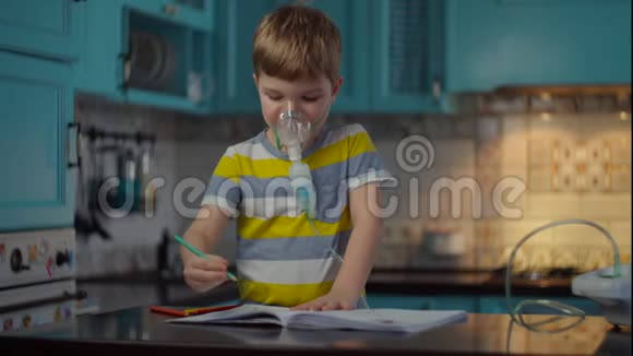 小男孩使用吸入器治疗流感或呼吸道病毒等疾病并在家用彩色铅笔画画视频的预览图