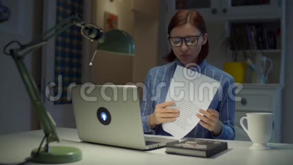 30多岁的年轻女教师戴着眼镜说话带着图表看着家里的笔记本电脑网上在线视频的预览图