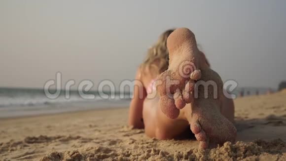 一位妇女在沙滩上以海为背景晒日光浴视频的预览图