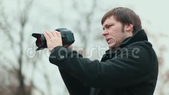 摄影师看着照相机的屏幕拍照视频的预览图