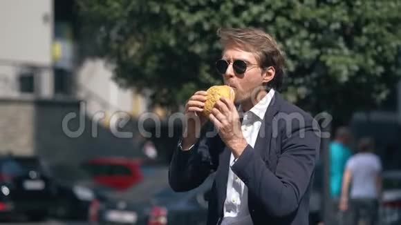 优雅的男人吃美味的汉堡视频的预览图