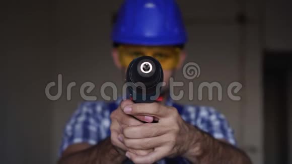 一个男建筑工人拿着电动螺丝刀或电钻视频的预览图