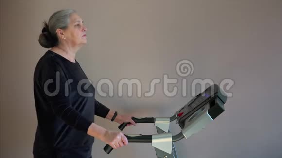 老年妇女按下按钮改变训练步行模式视频的预览图