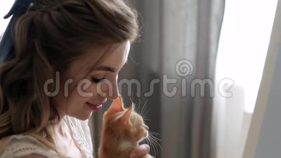 窗口的女孩画画和小猫玩刷子视频的预览图