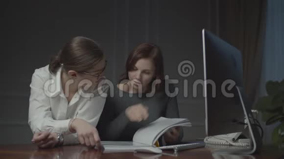 两个女商人晚上在办公室处理文件女同事讨论工作问题视频的预览图