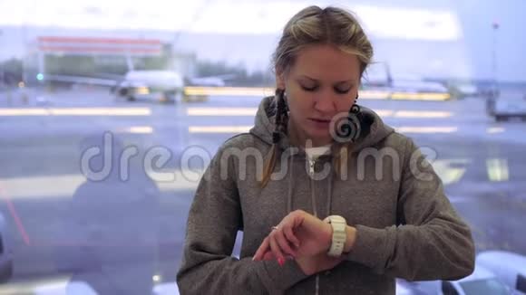 机场一位兴奋的女乘客看着她的手表视频的预览图