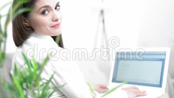 在手提电脑上工作的商务女性微笑视频的预览图