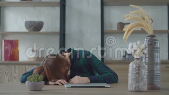 昏昏欲睡的30多岁的女工躺在桌子上站起来打开笔记本电脑试图工作女子关闭笔记本电脑视频的预览图