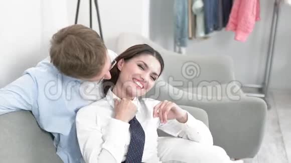 坐在沙发上的男人亲吻女孩的脖子视频的预览图