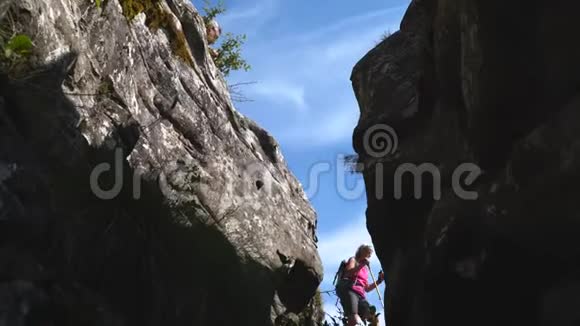 游客在岩石上跳过峡谷旅行者在夏天徒步旅行视频的预览图