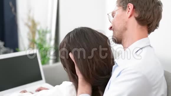 年轻男性为背景电脑打字的女性做头部按摩视频的预览图