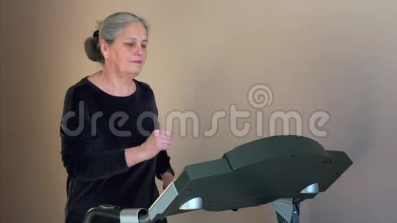 跑在跑步机上的运动高级女性训练她的耐力心脏视频的预览图