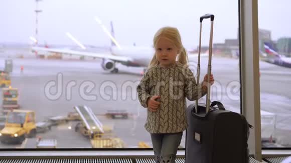 带着手提箱的女孩子在机场孩子在机场候机室视频的预览图