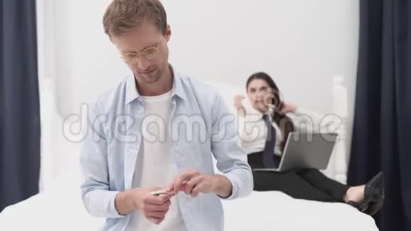一个年轻的男人在他妻子工作的时候做一个男人视频的预览图