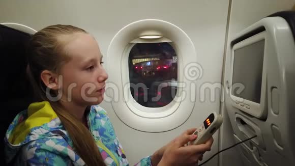 女孩拿着遥控器在飞机上娱乐系统视频的预览图