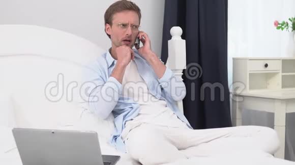 一个年轻人在一个明亮的房间里用电话说话视频的预览图