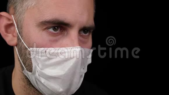 一个戴着医用口罩的病人把药丸放进嘴里视频的预览图