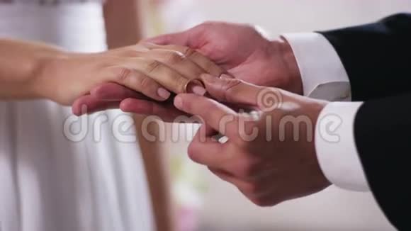 金婚戒指和新婚夫妇的双手紧紧抓住一个男人的手手指上戴着订婚戒指视频的预览图