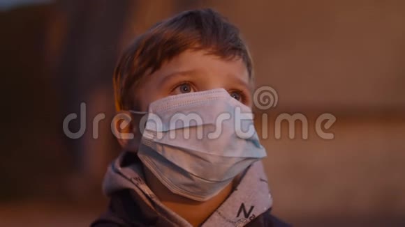 在冠状病毒COVID19大流行爆发期间在携带医用防护面罩的男孩封闭在庇护所紧急警报视频的预览图