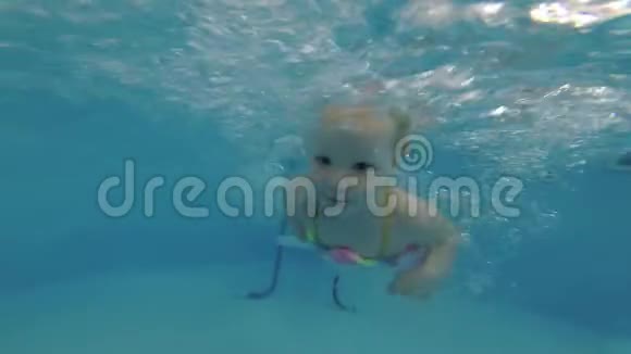 小女孩在游泳池里学在水下游泳视频的预览图