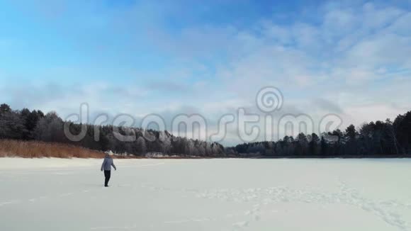 冬天一大群年轻女子小心翼翼地穿过一个冰冻的湖视频的预览图