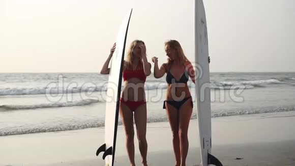 两个穿比基尼冲浪的女人在海边冲浪视频的预览图