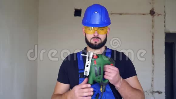 一个有胡子的严肃的男建筑工人的肖像在室内穿制服的工人视频的预览图