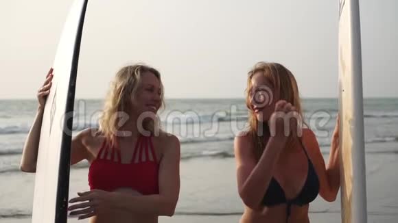 两个穿比基尼的性感女人在海上冲浪慢动作视频的预览图