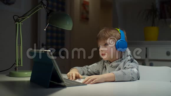 学龄前儿童彩色耳机使用平板电脑在线教育在家孩子喜欢上学视频的预览图