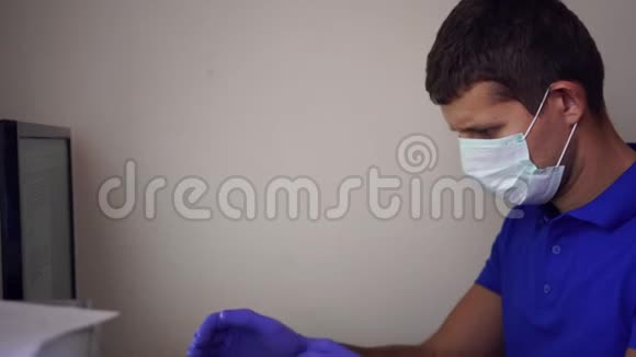一个戴着医用口罩的男人在家里用电脑工作检疫冠状病毒家庭办公室视频的预览图