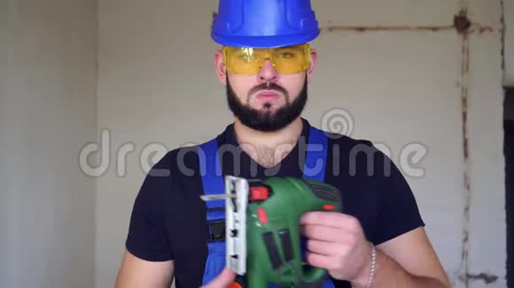 带电锯的男工一个有电锯的建筑工人的肖像视频的预览图