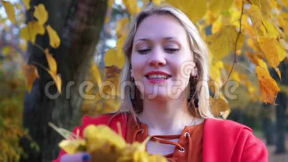 公园里的女孩抛出秋叶秋天一个美丽女人的肖像视频的预览图
