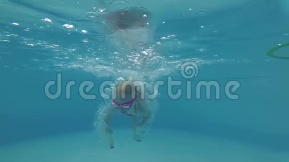 一个孩子在游泳池里水下的肖像一个女孩在游泳池里游泳视频的预览图