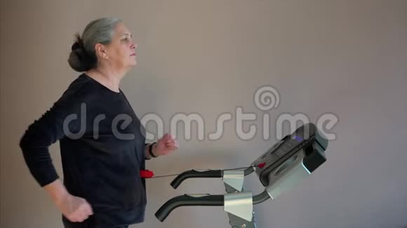 微笑的老年妇女在跑步机上行走她的第一个训练日视频的预览图