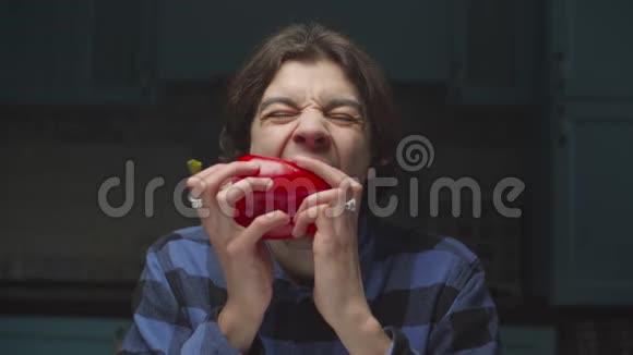 20多岁的年轻人饿着肚子在厨房里滑稽地吃红辣椒吃起来真有趣视频的预览图