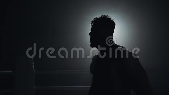 愤怒的戴着拳击手套的男人情绪化地站在拳击场上慢动作剪影拳击概念视频的预览图