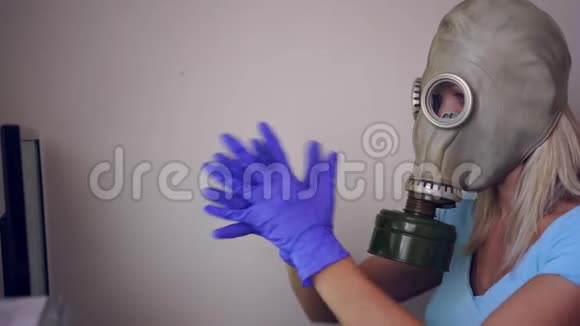 一个戴着防毒面具和医用手套的女人在家里用电脑工作视频的预览图
