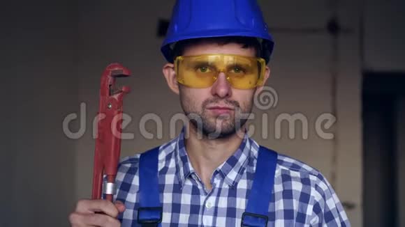 一个年轻的男水管工手里拿着一把大扳手视频的预览图