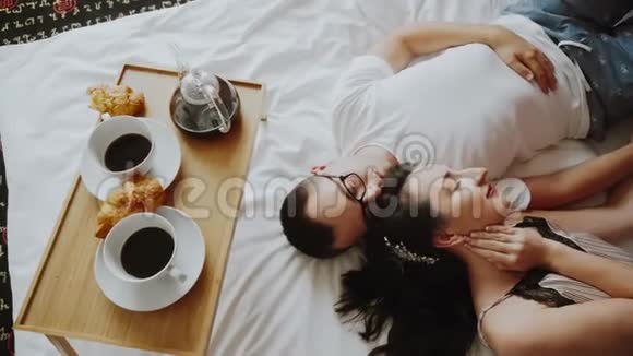 浪漫的情侣躺在床上闭着眼睛早上吃早餐视频的预览图