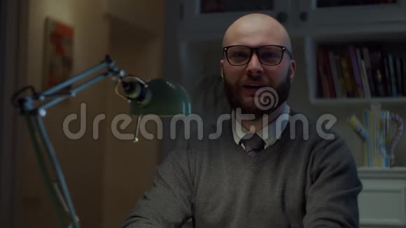 一个30多岁的大胡子戴眼镜的男人用拇指向上看着家里的摄像机有感情地说话在线教育过程网络摄像头视频的预览图