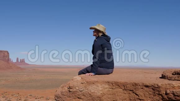 游客戴着牛仔帽坐在悬崖的观景点在纪念碑山谷乌萨视频的预览图