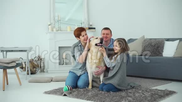 一家家庭和他们的拉布拉多犬一起享受家庭生活视频的预览图