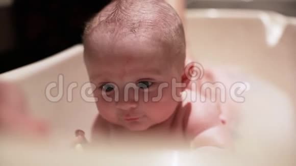 4个月大的婴儿正在洗澡躺在肚子上抬起头从前面看视频的预览图