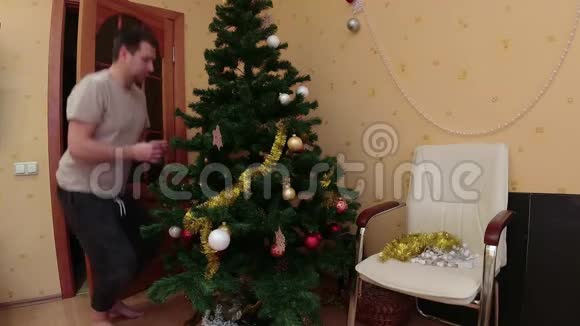 男人在家里卸下圣诞树视频的预览图