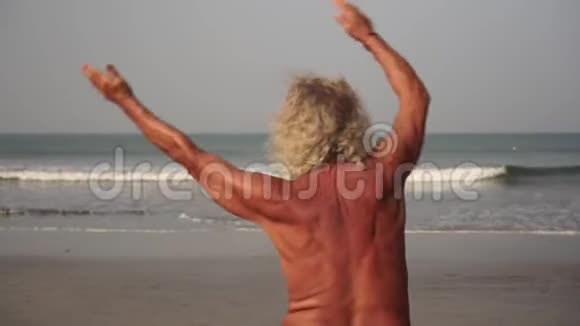 老人去海滩上运动成年男子正在海滩上训练视频的预览图